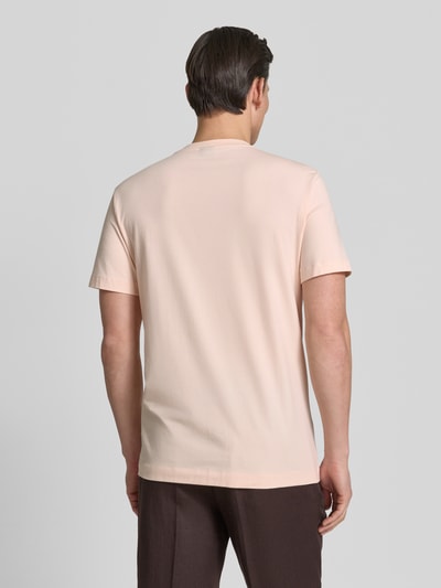 Männermodel trägt T-Shirt mit Rundhalsausschnitt Modell 'Carlonito' von JOOP! Collection, hellbeige, glatte Textur, Ganzkörperansicht Rückansicht. Baumwoll-Mix mit Stretch-Anteil, Straight Fit, Label-Detail sichtbar.