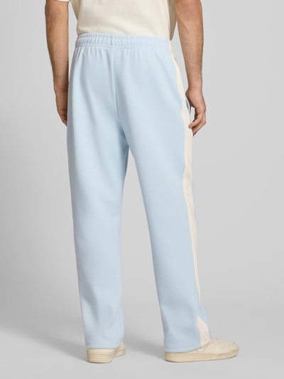 Männermodel trägt Straight Fit Sweatpants mit Logo-Stitching von KARL KANI in Hellblau mit Elastischer-Material-Mix, Ziernähte, Bund, Ganzkörperansicht Rückansicht. Herren Sweatpants, Innenbeinlänge 73 cm bei Größe M.