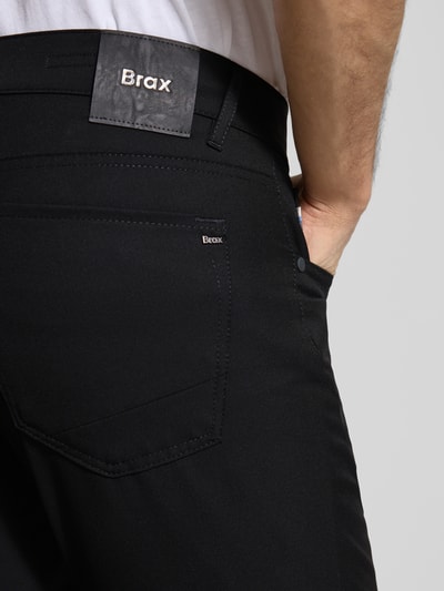 Männermodel trägt Hose mit Eingrifftaschen Modell 'Chuck' von Brax in Schwarz, Material-Mix mit Viskose-Anteil, Nahaufnahme Rückansicht.