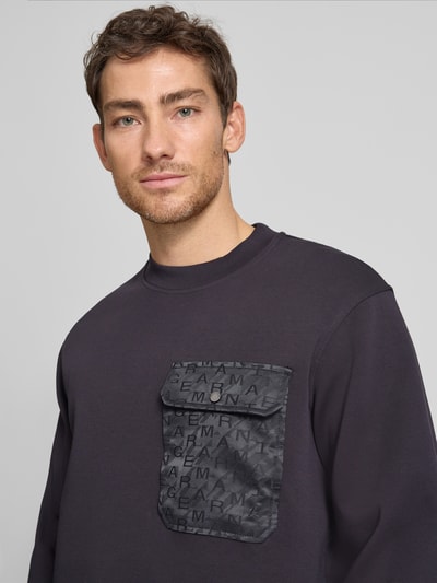 Männermodel trägt Sweatshirt mit Rundhalsausschnitt und Brusttasche von ARMANI EXCHANGE aus Baumwoll-Mix mit Stretch-Anteil, Regular-Fit, Nahaufnahme Oberkörper.