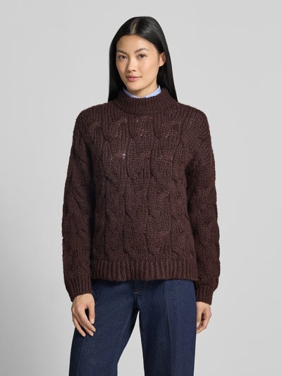 Frauenmodel trägt Regular Fit Pullover mit Rundhalsausschnitt Modell 'MAYBE' von VERO MODA in Dunkelbraun mit Strickmuster, Ganzkörperansicht von vorne.