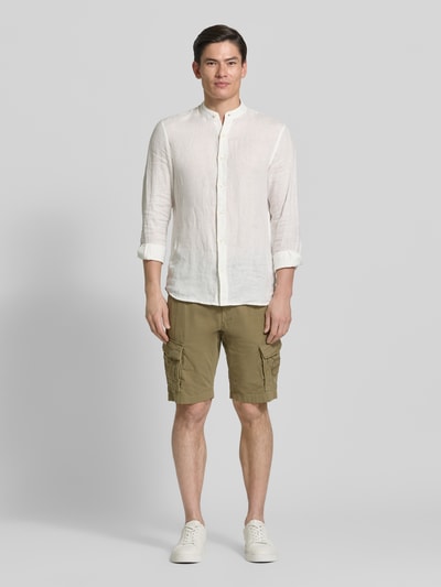 Männermodel trägt Bermudas mit Pattentaschen und Label-Stitchings von PME Legend in Khaki mit Knopf-Reißverschluss, Ganzkörperansicht von vorne. Seitliche Eingrifftaschen, Pattentaschen mit Klettverschluss, Motiv- und Label-Stitchings, Gesäßtaschen, Label-Details, Bundweite 41 cm, Innenbeinlänge 26 cm bei Größe 32.