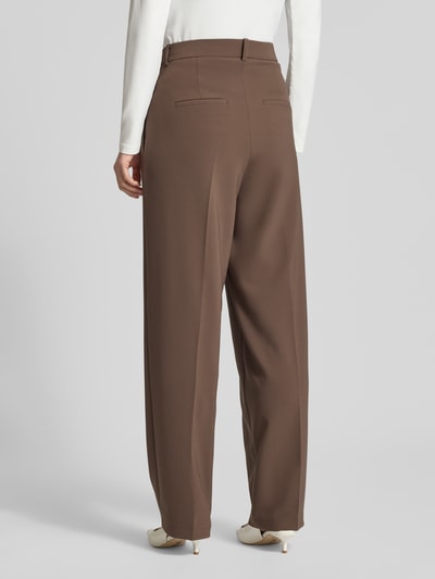 Frauenmodel trägt Wide Fit Stoffhose mit Gesäßtaschen Modell 'Emilie' von Cambio in Braun, Bügelfalten, Ganzkörperansicht Rückansicht.