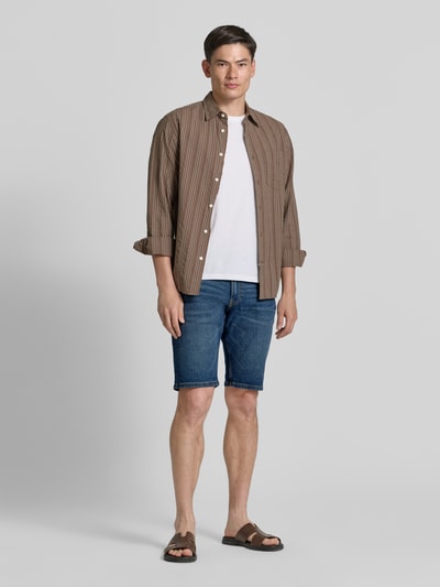 Männermodel trägt Regular Fit Jeans-Bermudas aus Baumwoll-Mix von s.Oliver RED LABEL im 5-Pocket-Design, Denimoptik, Ganzkörperansicht von vorne.