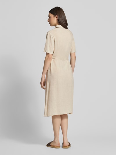Frauenmodel trägt figurumspielendes Freizeitkleid aus Viskose-Leinen-Mix Modell 'PIA' von Pieces in Beige, Midi-Länge, strukturierte Flammgarn-Optik, Ganzkörperansicht Rückansicht.
