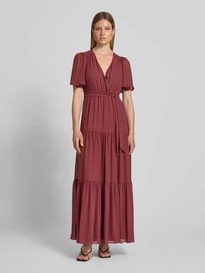 Frauenmodel trägt Abendkleid mit V-Ausschnitt und Bindegürtel von Christian Berg Cocktail, Chiffon, A-Linie, Stufen-Look, Maxikleid, Ganzkörperansicht von vorne. Rückenlänge bei Größe 36: 151 cm, Brustweite: 41 cm, Ärmellänge: 30 cm.