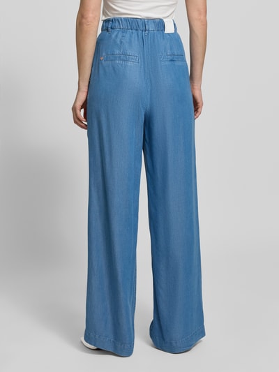 Frauenmodel trägt Wide Fit Jeans aus reinem Lyocell mit Bundfalten von Marc Cain in Hellblau, teilelastischer Bund, Paspeltaschen, Ganzkörperansicht Rückansicht, Damen Jeans, Innenbeinlänge 83 cm, Bundweite 36 cm, Eingrifftaschen, Knopf- und Reißverschluss.