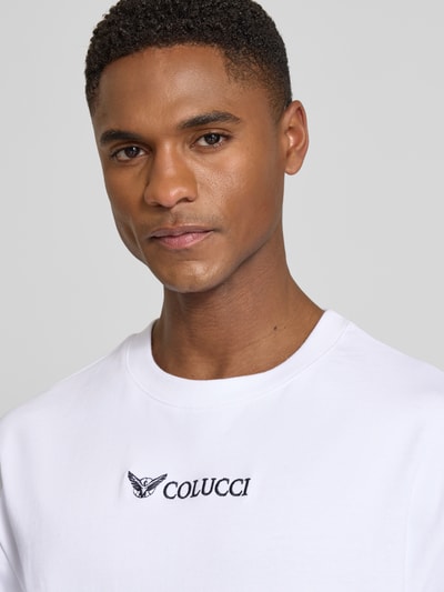 Männermodel trägt weißes Relaxed Fit T-Shirt mit Logo-Stitching Modell 'Ikarus' von COLUCCI, reine Baumwolle, Nahaufnahme Oberkörper.
