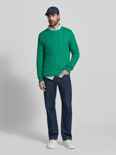 Männermodel trägt Regular Fit Strickpullover aus reiner Baumwolle von Polo Ralph Lauren, Optik: Unifarben, Zopfmuster, Ganzkörperansicht von vorne.