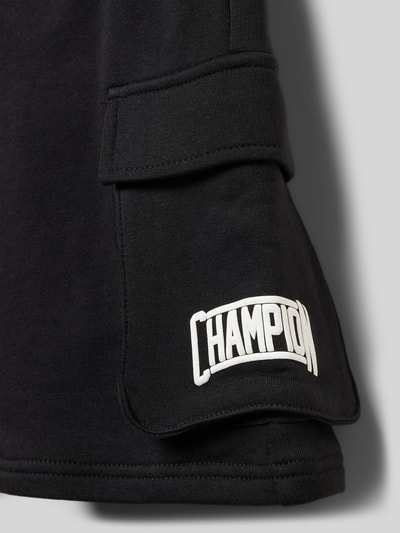 Produktfoto, czarne Bermudas aus Baumwoll-Mix mit Label-Detail von CHAMPION, prosta forma, elastyczny pas z tunelem, kieszenie boczne, kieszenie cargo, logo na kieszonce, gładka faktura, Szerokość w rozmiarze 140: 30 cm, długość nogawki od wewnątrz: 22 cm