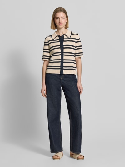 Frauenmodel trägt Strickshirt mit Knopfleiste Modell 'Dertiny' von OPUS aus Baumwoll-Mix im Allover-Look, Regular-Fit, Umlegekragen, Ganzkörperansicht von vorne.