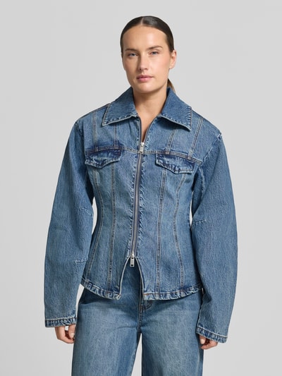 Frauenmodel trägt Jeansjacke aus Baumwoll-Mix Modell 'Melu' von Gestuz in Blau mit Zweiwege-Reißverschluss, Nahaufnahme Oberkörper.