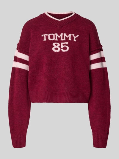 Produktfoto, Oversized Strickpullover mit Woll-Anteil von Tommy Jeans w kolorze bordowym, dzianina gładka, napis, długie rękawy, prążkowane wykończenia.