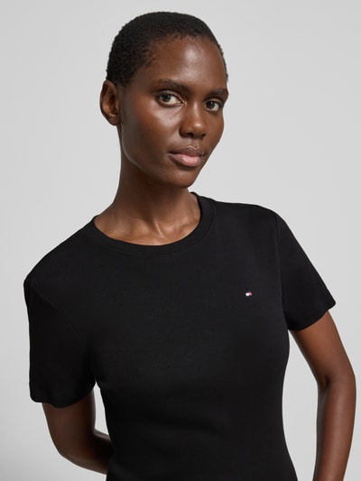 Frauenmodel trägt Slim Fit T-Shirt aus reiner Baumwolle von Tommy Hilfiger, Optik: Unifarben, Logo-Stitching, Rundhals, Kurzarm, Jersey, Nahaufnahme Oberkörper.
