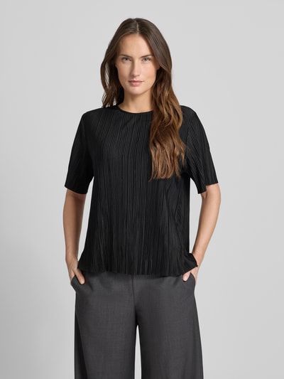 Frauenmodel trägt Relaxed Fit Kurarzm Bluse mit Rundhalsausschnitt Modell 'Uma' von Samsøe Samsøe, Schwarz mit feiner Plissee-Struktur, elastischer Material-Mix, Ganzkörperansicht von vorne.