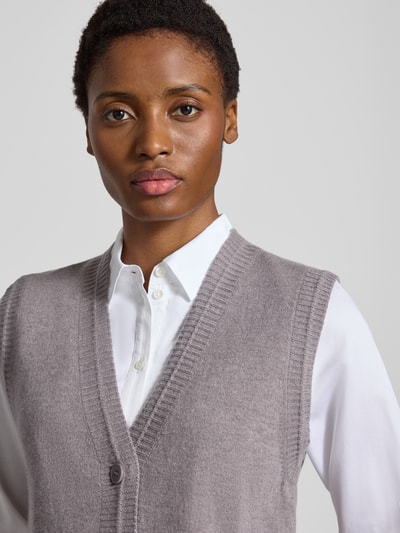 Männermodel trägt Strickweste mit Kaschmir-Anteil von windsor., Mieszanka żywej wełny i kaszmiru, krój regular fit, dekolt w serek, na całej długości listwa guzikowa, kieszenie z wypustką, prążkowane wykończenia, długość tyłu w rozmiarze 36: 53 cm, kolor szary, tekstura miękka. Nahaufnahme górnej części ciała.