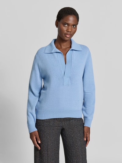 Frauenmodel trägt Relaxed Fit Pullover aus Woll-Mix von Victoria Beckham in Hellblau mit Strick-Optik, Umlegekragen und V-Ausschnitt, Damen Pullover mit Kaschmir-Anteil, Ganzkörperansicht von vorne.