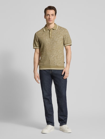 Männermodel trägt Regular Fit Poloshirt im Allover-Look von Jack & Jones Premium aus reiner Baumwolle mit Polokragen und Knopfleiste, Ganzkörperansicht von vorne.