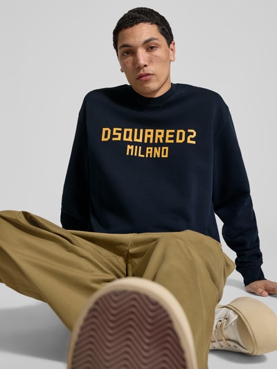 Männermodel trägt Cool Fit Sweatshirt aus reiner Baumwolle von Dsquared2, dunkelblau mit Label-Print, elastische Abschlüsse, Nahaufnahme Oberkörper.