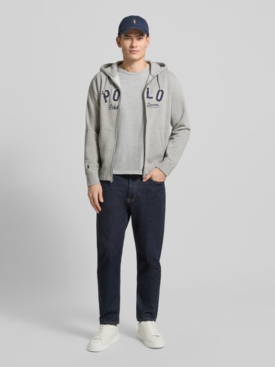 Männermodel trägt Sweatjacke mit Label-Stitching und Känguru-Tasche von Polo Ralph Lauren in Grau, Baumwoll-Mix, Regular-Fit, Ganzkörperansicht von vorne.