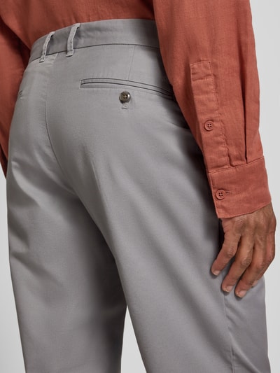 Männermodel trägt Tapered Fit Hose mit Gesäßtaschen von MCNEAL, mieszanka bawełny, drapowania, kieszenie z tyłu, detal tyłu, zbliżenie