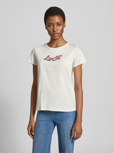 Frauenmodel trägt T-Shirt mit Strasssteinbesatz von Liu Jo in Weiß mit Label-Print, Baumwolle, gerader Schnitt, Ganzkörperansicht von vorne.