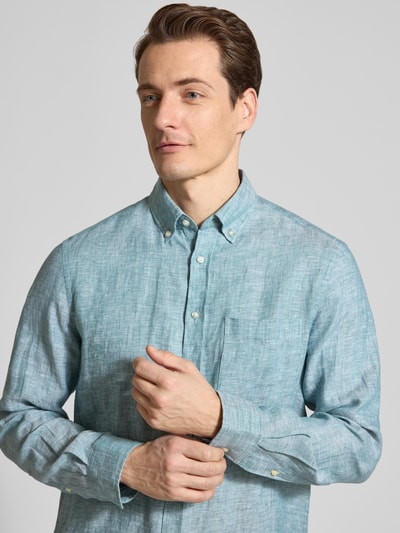 Männermodel trägt Slim Fit Leinenhemd mit Brusttasche von Christian Berg Men in hellblau, reine Leinenstruktur, Nahaufnahme Oberkörper.