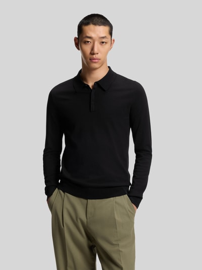 Männermodel trägt Slim Fit Strick-Poloshirt aus Viskose-Mix Modell 'SAN PIPPO-CV' van HUGO, effen zwart, fijn ribbreisel, polokraag, lange mouw, ribgebreide boorden, Ganzkörperansicht von vorne.