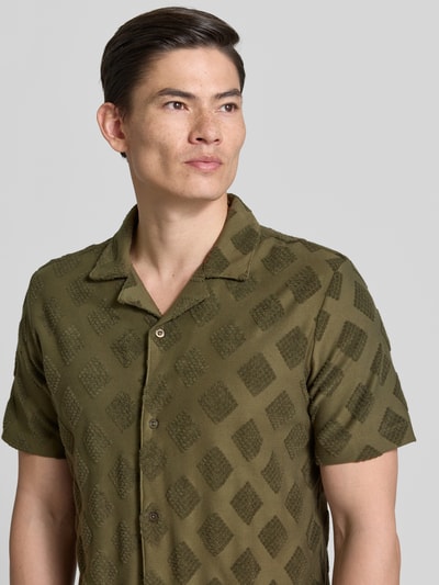 Männermodel trägt Slim Fit Poloshirt mit Strukturmuster von Fynch-Hatton aus Baumwoll-Mix, Reverskragen, Knopfleiste, kurzärmelig, Nahaufnahme Oberkörper.