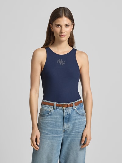Kobiece modelka nosi Tanktop in Ripp-Optik mit Logo od Guess, mieszanka materiałów z dodatkiem streczu, krój slim fit, efekt prążkowania, logo, długość tyłu w rozmiarze S: 50 cm, granatowy, gładka tekstura, całkowity widok z przodu.