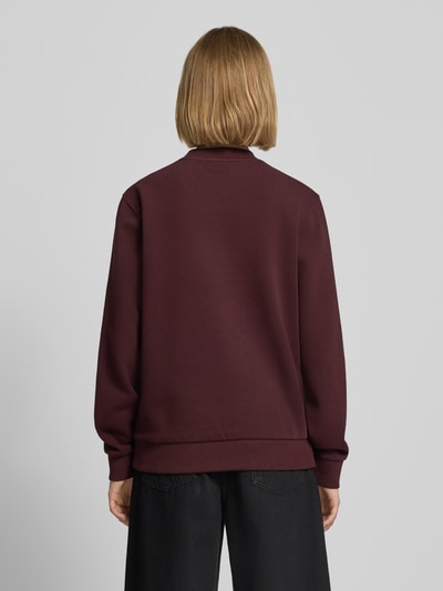 Modelka kobieca nosi Relaxed Fit Sweatshirt aus Baumwoll-Mix od Lacoste, kolor bordowy, jednolita faktura, widok całej sylwetki z tyłu. Bluza damska od Lacoste.