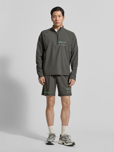 Männermodel trägt Shorts mit elastischem Bund Modell 'HALO AIR' von HALO, Herren Shorts aus Material-Mix mit Stretch-Anteil, Regular-Fit, olivgrün, Bundweite 40 cm, Innenbeinlänge 21 cm, Ganzkörperansicht von vorne.