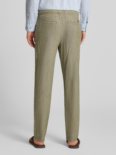 Männermodel trägt Hose aus Leinen-Baumwoll-Mix Modell 'MARCO' von Blend, olivegrün, strukturierte Oberfläche, Regular-Fit, Ganzkörperansicht Rückansicht, elastischer Bund, Bundweite bei Größe M 42 cm, Innenbeinlänge bei Größe M 80 cm.