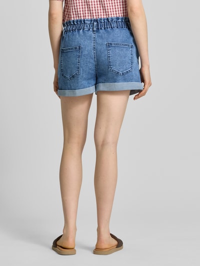 Frauenmodel trägt Straight Fit Shorts in Denim-Optik mit Viskose-Anteil von Apricot, Elastischer Baumwoll-Mix, Gesäßtaschen, Ganzkörperansicht Rückansicht.