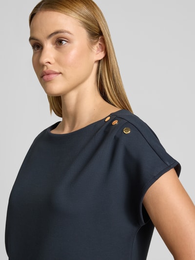Frauenmodel trägt T-Shirt mit Zierknöpfen und Rundhalsausschnitt von comma in Dunkelblau, Viskose-Mix, Nahaufnahme Oberkörper.
