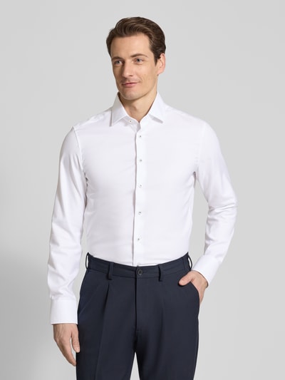Männermodel trägt Slim Fit Business-Hemd mit Kentkragen von ETERNA aus reiner Baumwolle, Unifarben, Langärmelig, Ganzkörperansicht von vorne.