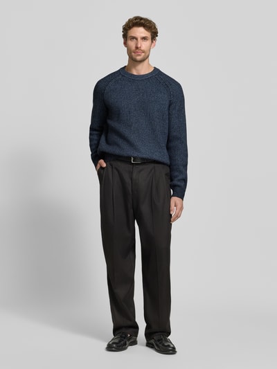 Männermodel trägt Regular Fit Pullover aus Woll-Mix Modell 'Kepler' von BOSS für BOSS Orange in Dunkelblau mit feiner Strickstruktur, Ganzkörperansicht von vorne.