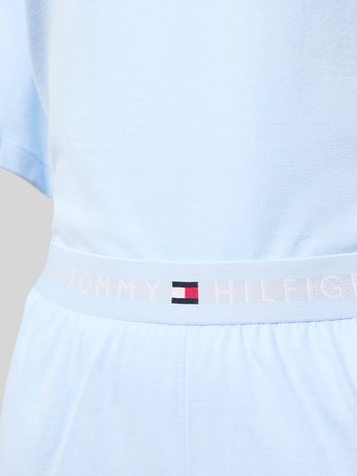 Vrouwenmodel draagt Regular Fit Pyjama aus reiner Baumwolle van TOMMY HILFIGER in lichtblauw, logo-elastische tailleband, effen kleur, korte mouwen, zachte katoenen textuur, detailopname taille.