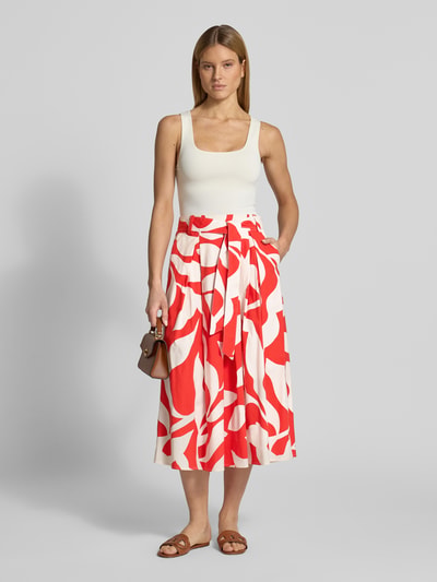 Kobiece model prezentuje Regular Fit Midirock mit floralem Allover-Print von More & More, mieszanka bawełny, plisy, czerwień i biel, odpinana tasiemka w talii, szerokość w rozmiarze 36: 37 cm, całkowita długość w rozmiarze 36: 87 cm, kwiatowy nadruk na całej powierzchni, Ganzkörperansicht z przodu.