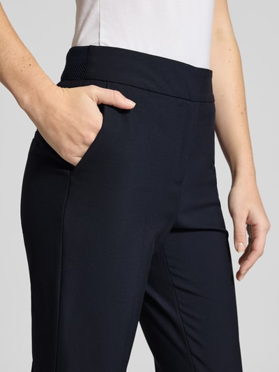 Frauenmodel trägt Regular Fit Schmale Hose mit Bügelfalten von s.Oliver BLACK LABEL, Optik: Unifarben, Nahaufnahme Oberkörper. Bund mit Struktur, seitliche Eingrifftaschen, elastischer Bund, angedeutete Gesäßtaschen.
