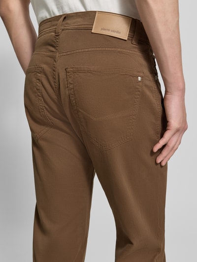 Männermodel trägt Regular Fit Hose mit Eingrifftaschen Modell 'Lyon' von Pierre Cardin, Baumwoll-Elasthan-Mix, Nahaufnahme Rückansicht. Bundweite 41 cm, Innenbeinlänge 80 cm, Farbe Braun, markantes Label, grobe Textur.