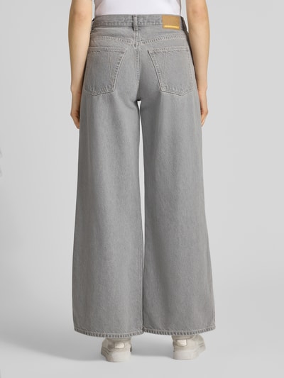 Frauenmodel trägt Wide Leg Jeans aus Lyocell-Baumwoll-Mix Modell 'ASTRAEAAS' von Armedangels in grauer Denim-Optik, 5-Pocket, Ganzkörperansicht Rückansicht.