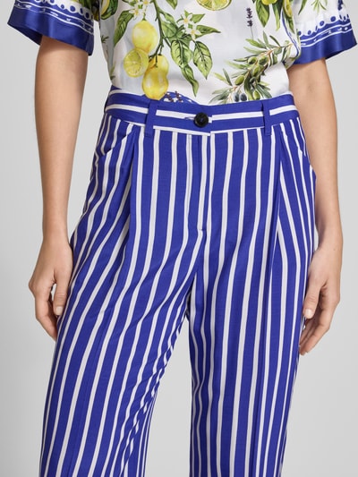 Frauenmodel trägt Hose aus Viskose im Allover-Look von Marc Cain, blau-weiß gestreift, mit Eingrifftaschen, Nahaufnahme Oberkörper.
