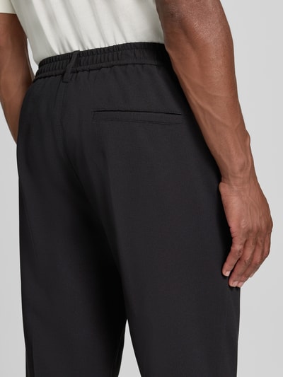 Mężczyzna prezentuje Regular Fit Hose mit Viskose-Anteil von Antony Morato, czarne, gładka faktura, Mieszanka materiałów z dodatkiem wiskozy, wpuszczane kieszenie, Kanty, Szerokość w rozmiarze 50: 44 cm, Długość wewnętrzna nogawki w rozmiarze 50: 78 cm, detal z tyłu, zapięcie na guzik i zamek błyskawiczny, wpuszczane kieszenie, widok na tył, detalaufnahme.