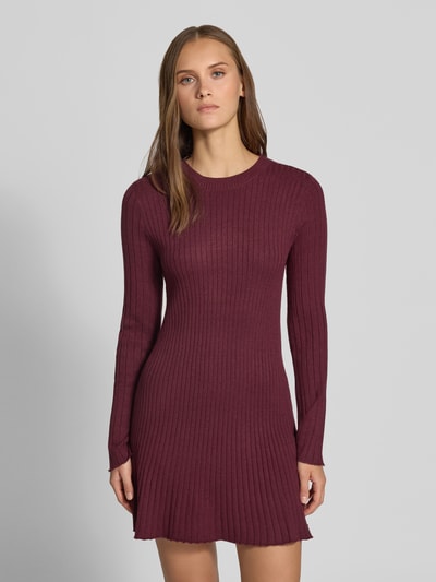 Frauenmodel trägt Eng anliegendes Freizeitkleid aus Viskose-Mix Modell 'MICHELLA' von ONLY in Dunkelrot mit Rippstruktur, Ganzkörperansicht von vorne, Damen Strickkleid von ONLY.