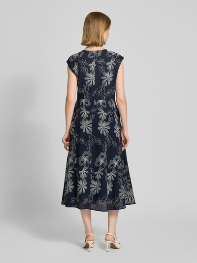 Frauenmodel trägt Midikleid mit Stitchings und Eingrifftaschen von Milano Italy, dunkelblauer Baumwoll-Mix mit floralen Nähten, A-Linie, Ganzkörperansicht Rückansicht.