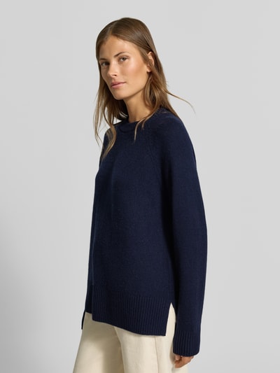 Frauenmodel trägt Regular Fit Pullover aus reinem Kaschmir in Strick-Optik von MYON in Dunkelblau, Rundhalsausschnitt, Seitenansicht, Ganzkörperansicht von vorne. Rückenlänge 68 cm, Ärmellänge 66 cm, reine Kaschmir-Textur.