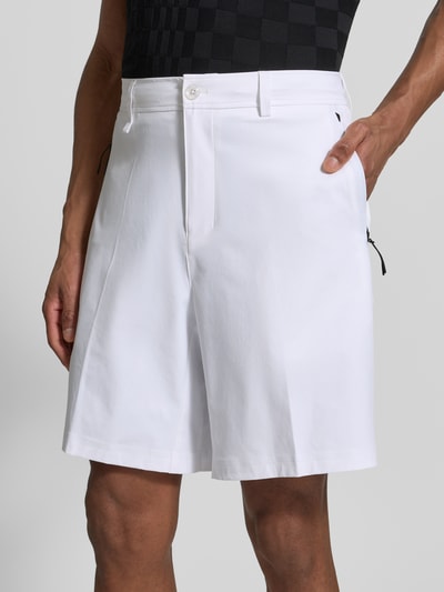 Männermodel trägt weiße Relaxed Fit Bermudas mit Label-Schriftzug Modell 'SPIRIT70' von BOSS Green X PORSCHE, Nahaufnahme Oberkörper.