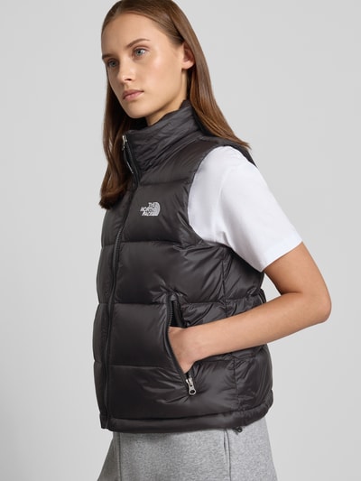 Frauenmodel trägt Steppweste mit Label-Stitching Modell 'HYDRENALITE DOWN A-LINE' von The North Face in Dunkelgrau mit Reißverschlusstaschen, Regular Fit, Stehkragen, Ganzkörperansicht von vorne. Rückenlänge, Schulterbreite und Brustweite bei Größe S laut Beschreibung.