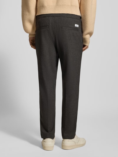 Männermodel trägt Tapered Bundfaltenhose mit Viskose-Anteil von Marc O'Polo Denim in Melange-Optik, seitliche Eingrifftaschen, Ganzkörperansicht Rückansicht.
